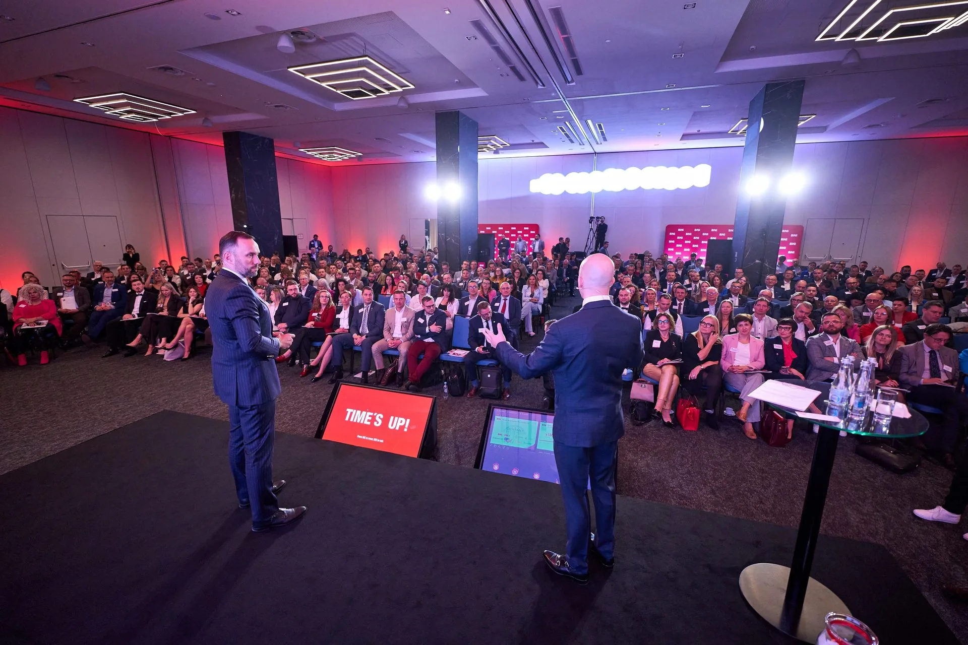 Pełna sala Ogólnopolskiej Konferencji BNI: kilkuset przedsiębiorców i dwóch prowadzących na scenie.